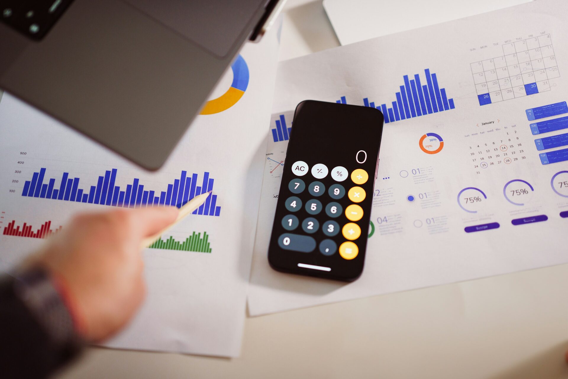 Rechner auf Finanzunterlagen mit Diagrammen und Statistiken