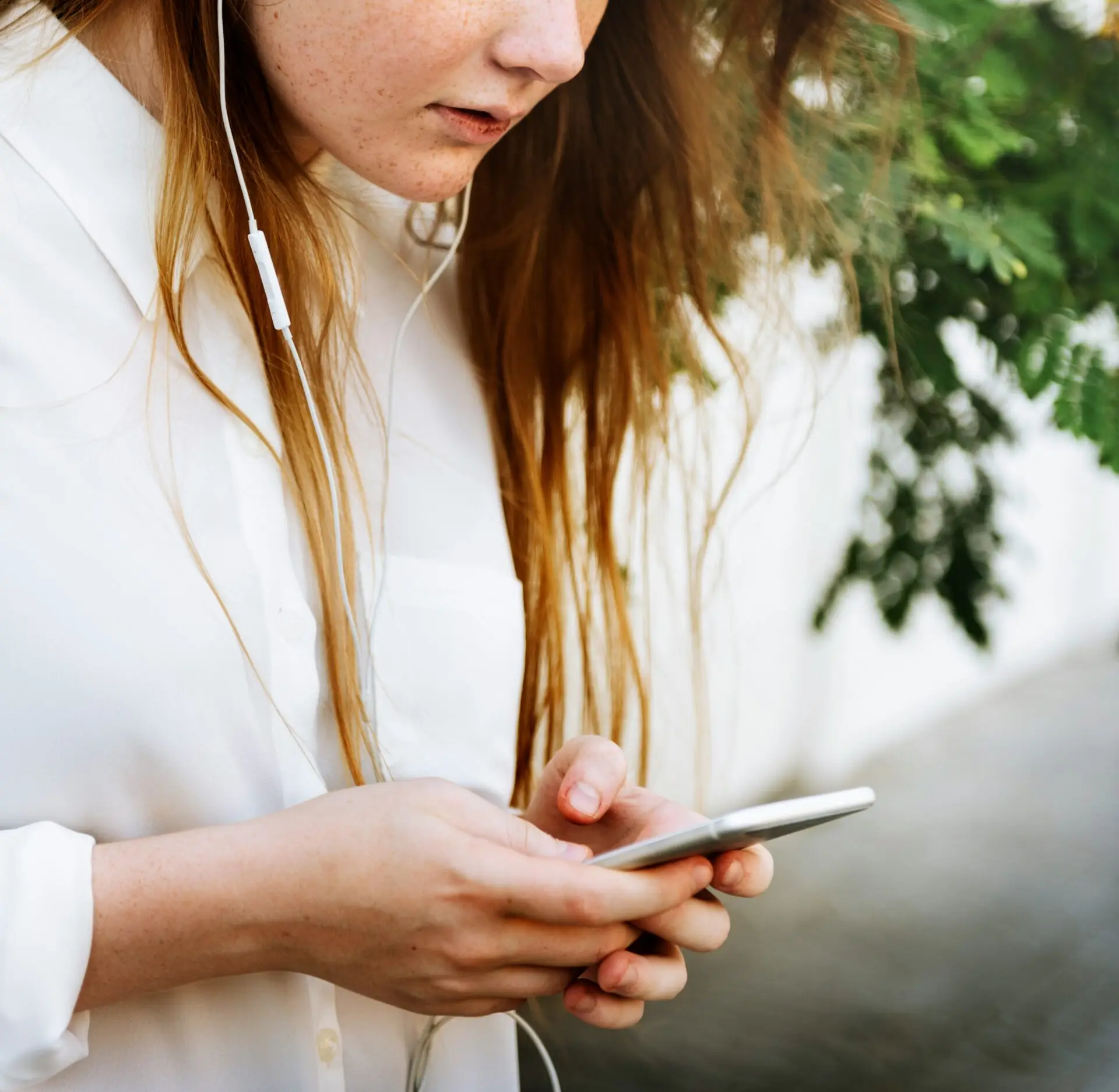 Person schaut auf Smartphone, Cyberstalking und unerwünschte Kontaktaufnahmen