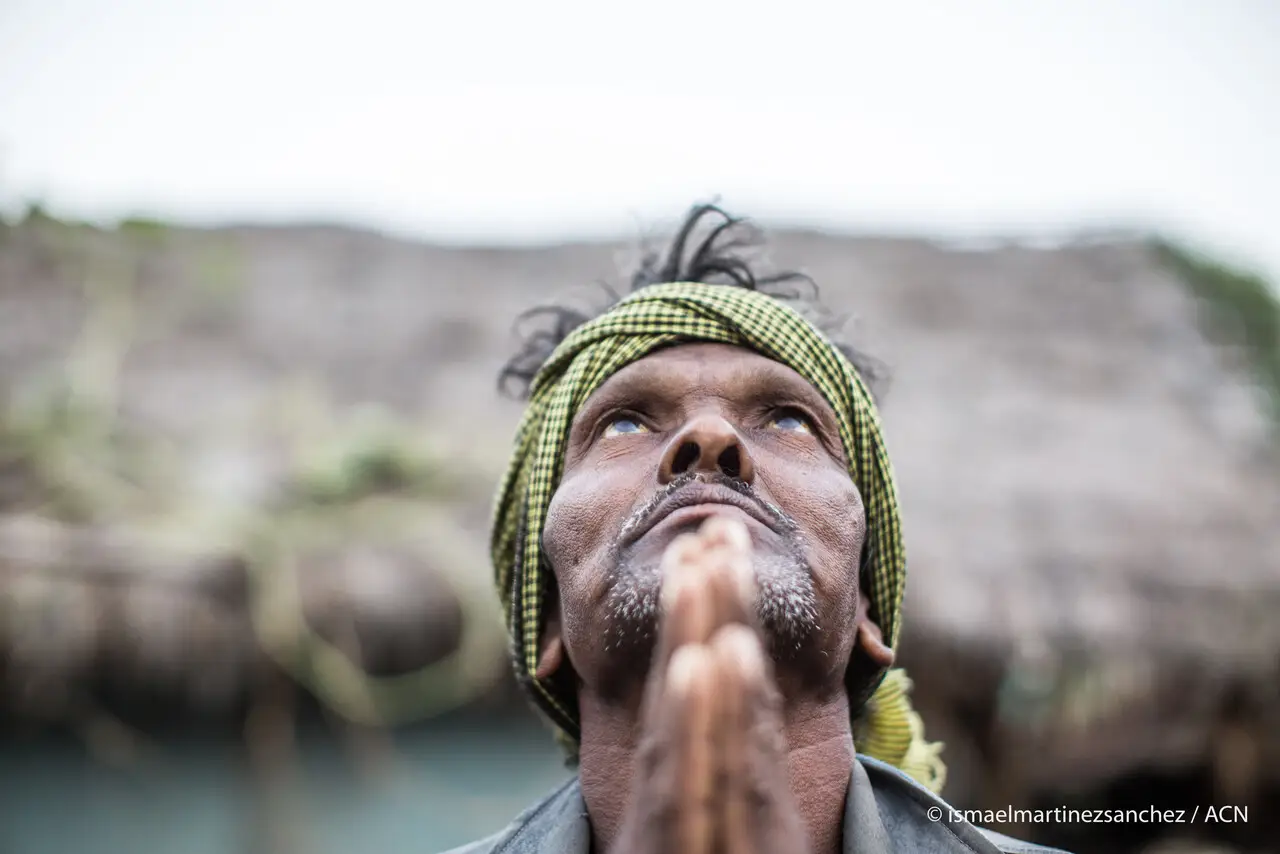Mann in Indien mit erhobenen Händen und Blick zum Himmel